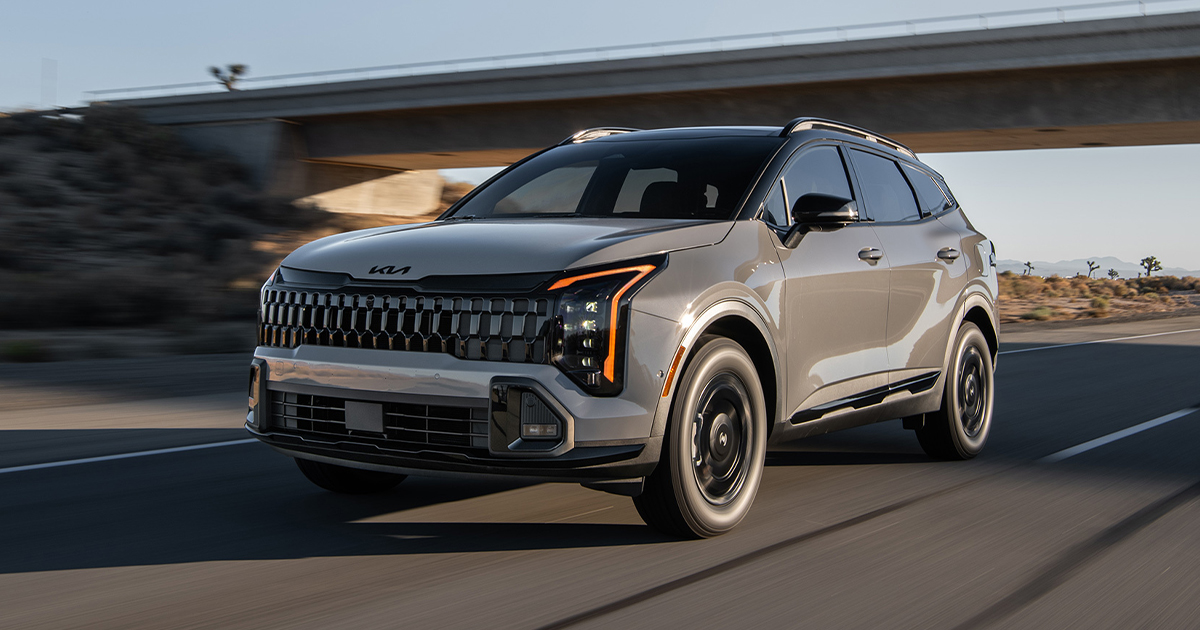 A silver Kia Sportage driving down a highway